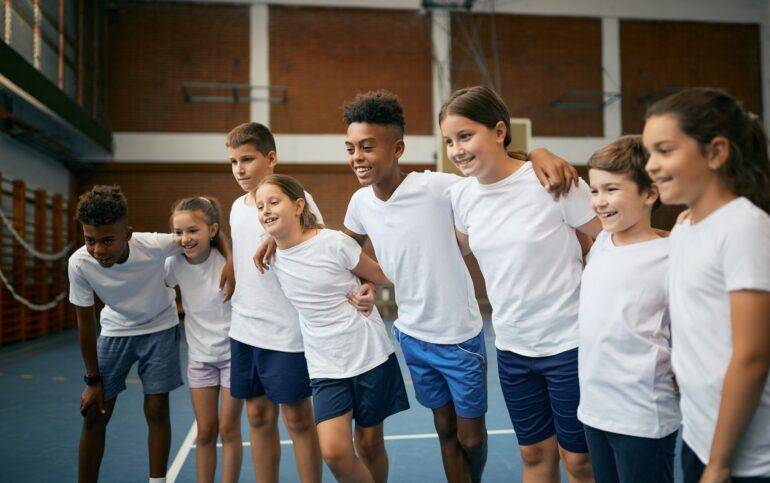 International Education on the Costa del Sol. Multi-ethnic group of happy school children having PE class at at school gym.